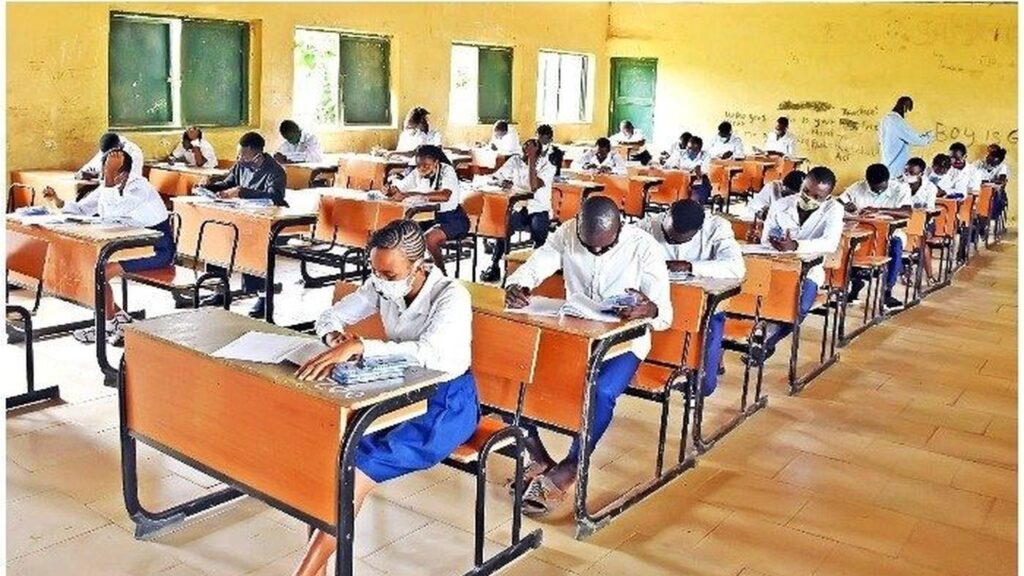 WAEC NECO Fee Hike Frozen as FG Reviews Policy 3 A wide shot of Nigerian secondary school students sitting for the WAEC or NECO examination in a classroom.